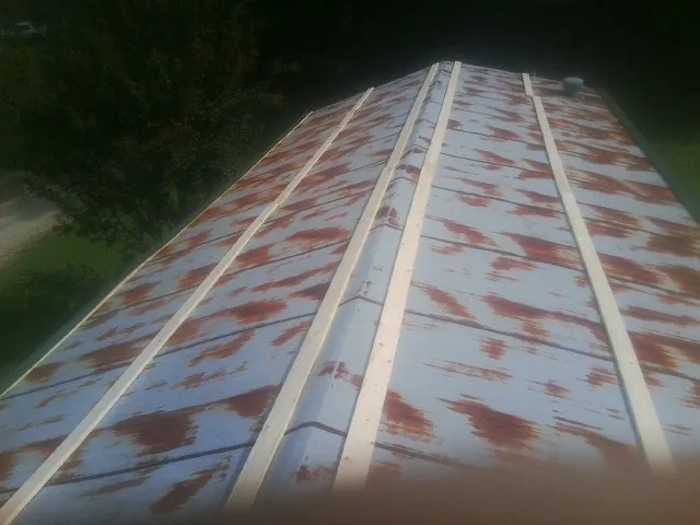 Rusted metal roof panels with new wood purlins before replacement — Storm Damage Roof Repair in Thomasville by Roofing Brothers