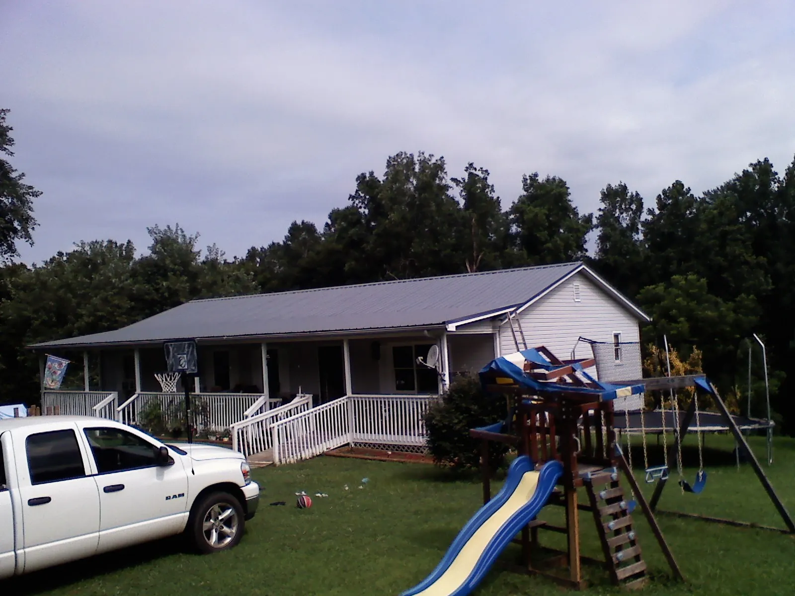 Dark metal roof on a country home with a full length front porch in Thomasville