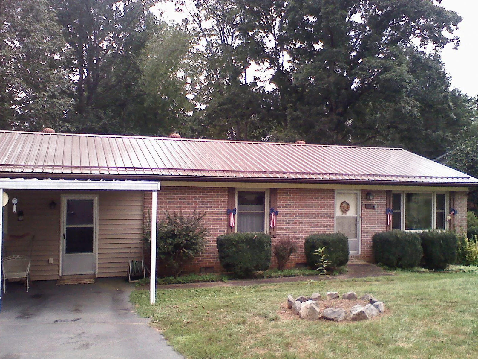 Bronze metal roof and carport on a brick ranch home — Roof Repair work by our crew in Thomasville