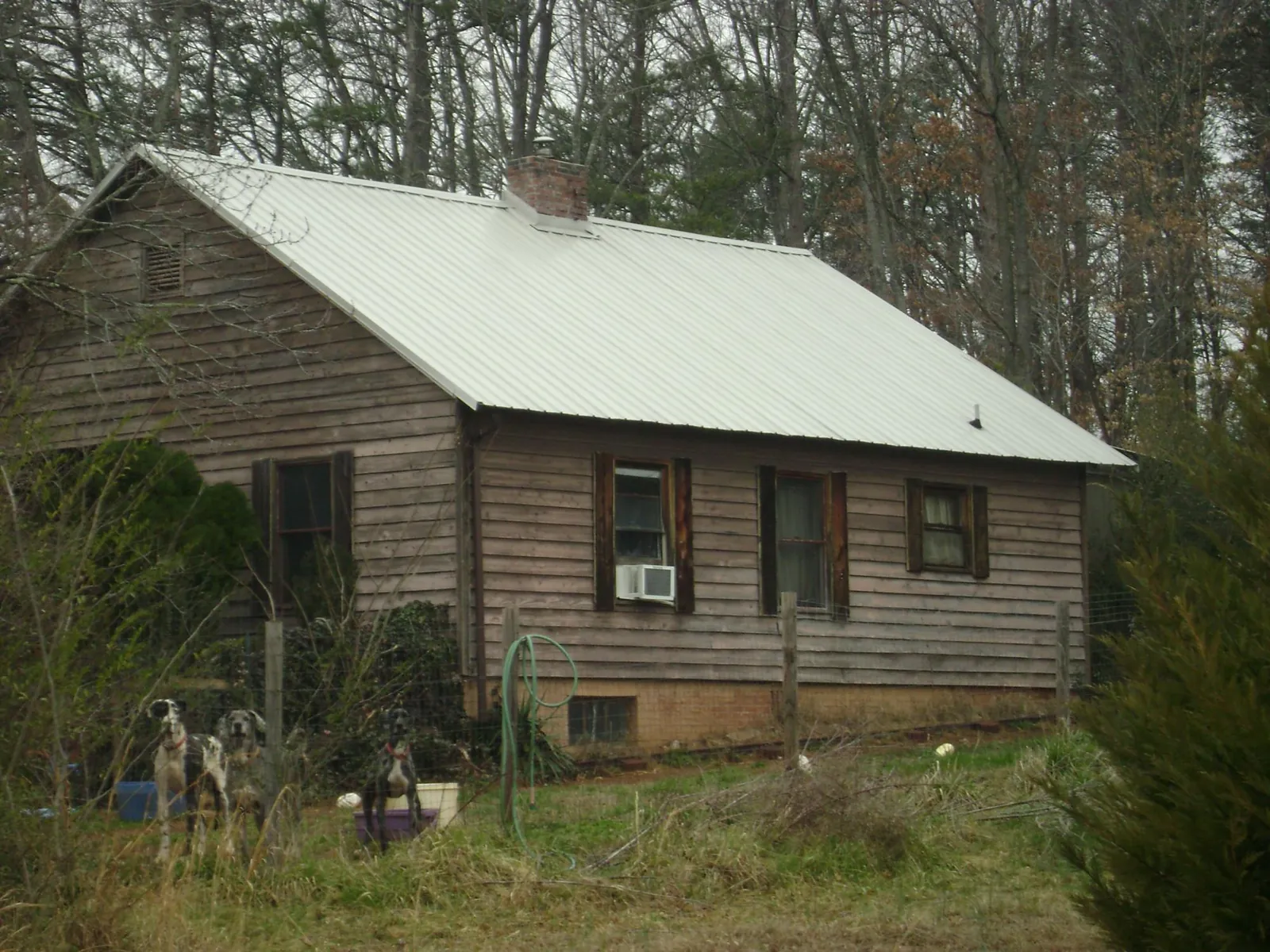 White metal roof on an old wood sided farmhouse, from a Asphalt Shingle Roof Repair job in Thomasville